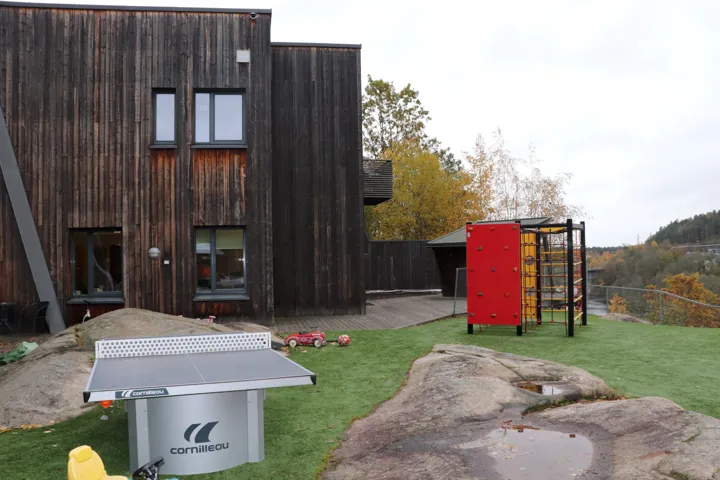 Bildet viser bakgården til til Krisesenteret i Telemark, med fin uteplass og lekeapparater.