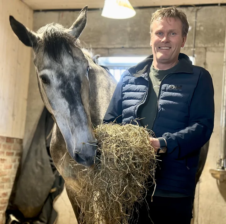 Geir Eddi Kalland i stallen sammen med en hest.