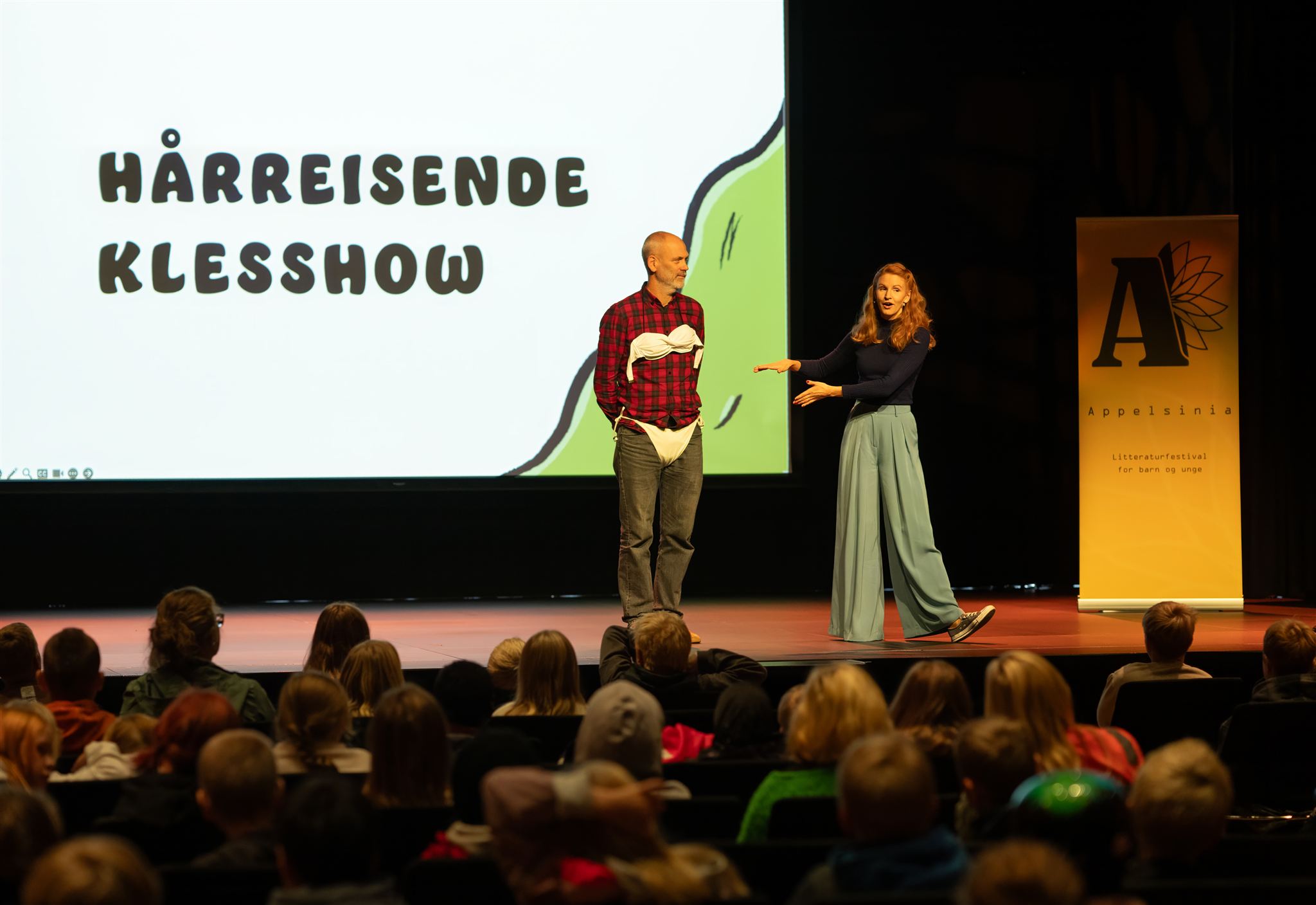 Ragnhild Holmås med en lærer på scenen.