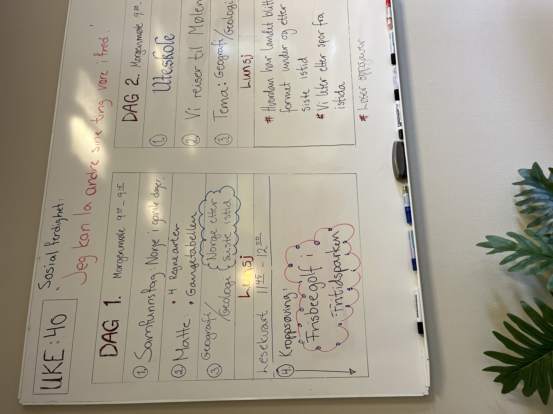 Tavle på vegg hvor det er skrevet tekst.