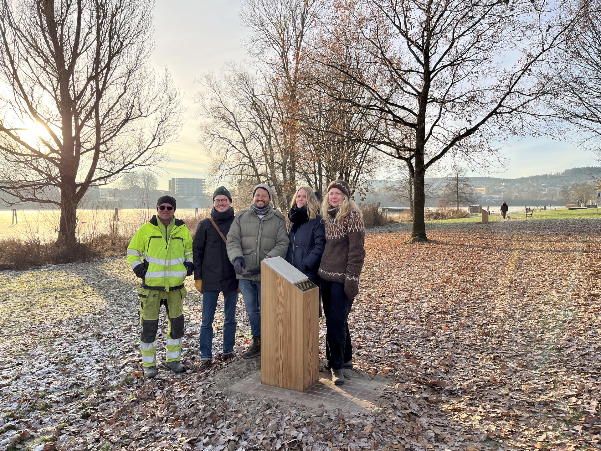 Fem personer som står på en tursti med trær i bakgrunnen.
