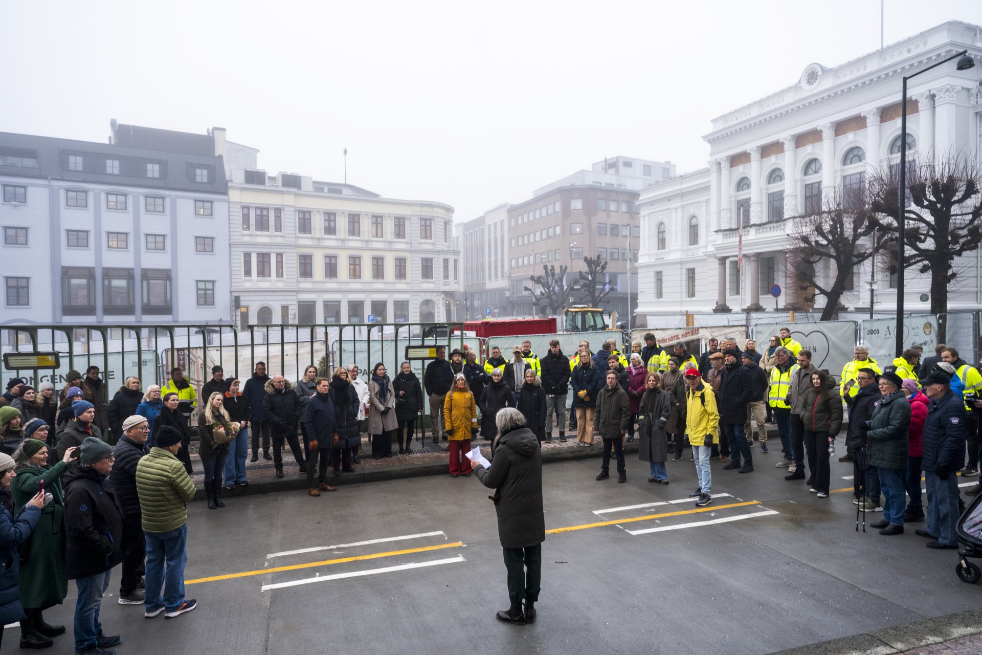 Mennesker i en bygate med bygninger rundt.